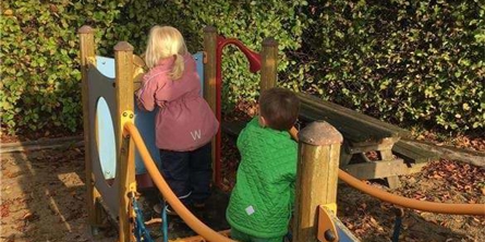 Børn der leger i klatrestativet